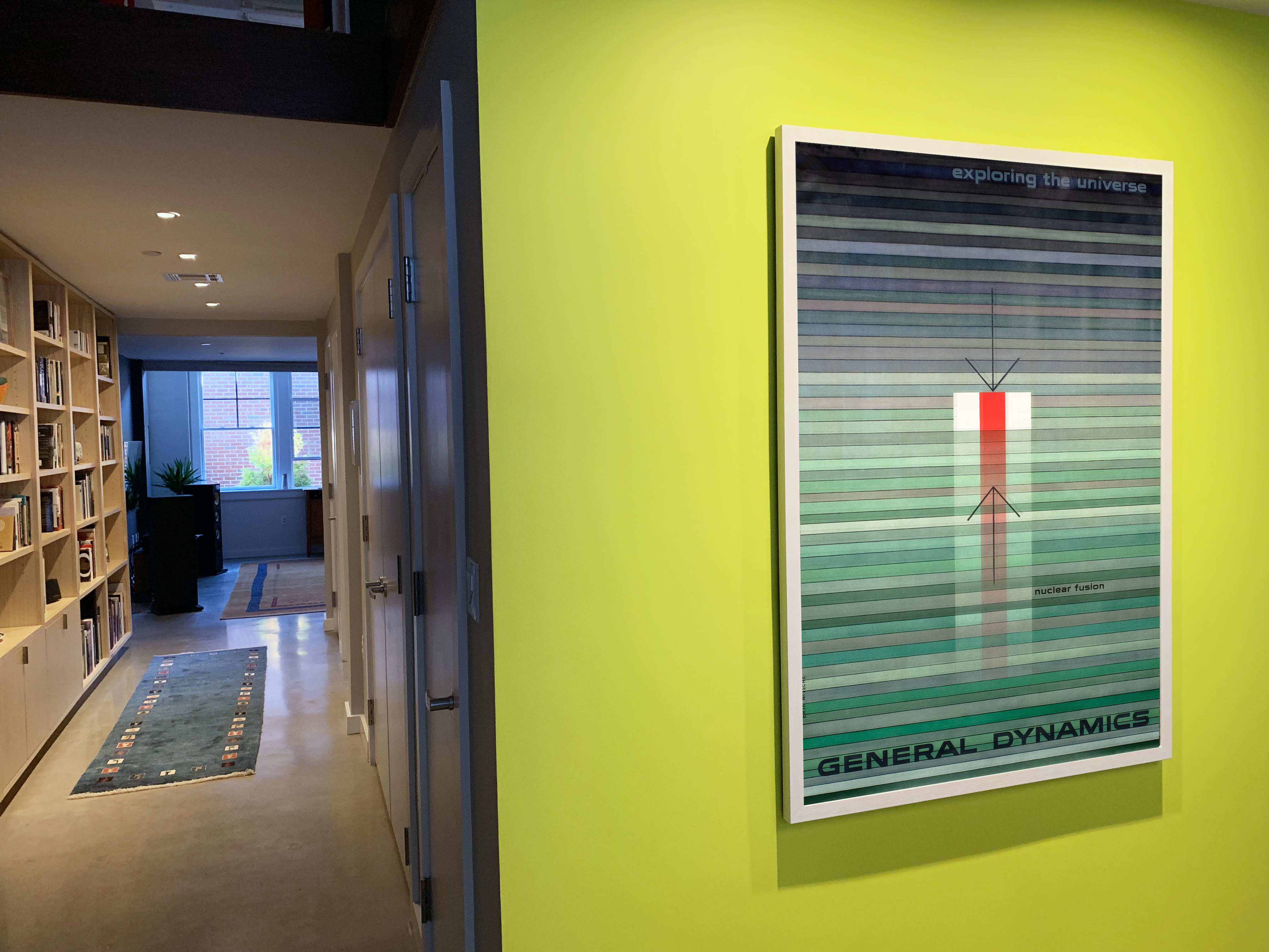 hallway with accent wall and General Dynamics poster; green, red, orange